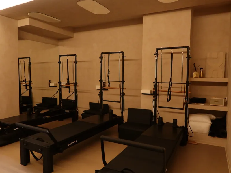 Sala de Pilates Reformer de Nudhe Studio con cuatro camas reformer con torre